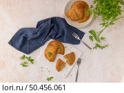 Meat patties and parsley leaves on white ceramic dishes in a kitchen counter top. Стоковое фото, агентство Ingram Publishing / Фотобанк Лори
