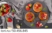 Caramel custard puddings on round slate on and dark kitchen countertop. Стоковое фото, агентство Ingram Publishing / Фотобанк Лори