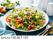 Tabbouleh salad. Tabouli salad with fresh parsley, onions, tomatoes, bulgur and chickpea. Healthy vegetarian food, diet. Стоковое фото, агентство Ingram Publishing / Фотобанк Лори