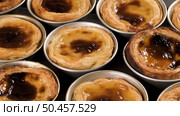Rows of freshly cooked egg tarts, traditional portuguese dessert, pastel de nata, custard tarts on metal tray. Стоковое фото, агентство Ingram Publishing / Фотобанк Лори
