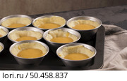 Egg tarts, traditional portuguese dessert, pastel de nata, custard tarts during home production on metal tray. Стоковое фото, агентство Ingram Publishing / Фотобанк Лори