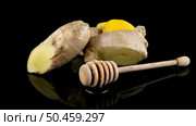 Ginger root drizzler with honey and lemon on black reflective background. Concept of natural ingredients to prevent colds. Стоковое фото, агентство Ingram Publishing / Фотобанк Лори