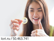 Young woman holding condom prevent pregnancy and Sexually transmitted diseases. Стоковое фото, агентство Ingram Publishing / Фотобанк Лори