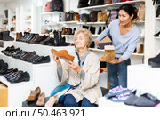 Friendly female sales consultant serves a mature woman who is going to try on shoes. Стоковое фото, фотограф Яков Филимонов / Фотобанк Лори