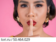 Beauty asian woman red lips and finger showing hush silence sign. Стоковое фото, агентство Ingram Publishing / Фотобанк Лори