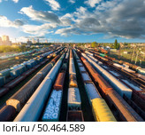Drone view of freight trains at sunset. Colorful railway cargo wagons on railroad. Aerial view of colorful wagons, city, blue sky with clouds. Depot of freight trains. Railway station. Transportation. Drone view of freight trains at sunset. Railway cargo wagons. Стоковое фото, агентство Ingram Publishing / Фотобанк Лори