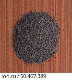 Top view of poppy seeds against red vinyl background. Стоковое фото, агентство Ingram Publishing / Фотобанк Лори