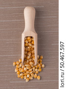 Top view of wooden scoop with corn against brown vinyl background. Стоковое фото, агентство Ingram Publishing / Фотобанк Лори