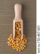 Top view of wooden scoop with corn against green vinyl background. Стоковое фото, агентство Ingram Publishing / Фотобанк Лори