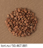Top view of circle of lentils against brown vinyl background. Стоковое фото, агентство Ingram Publishing / Фотобанк Лори