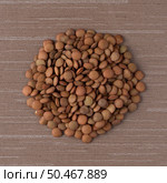 Top view of circle of lentils against brown vinyl background. Стоковое фото, агентство Ingram Publishing / Фотобанк Лори