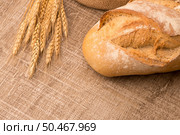 Rustic bread and wheat on an old vintage planked wood table. Стоковое фото, агентство Ingram Publishing / Фотобанк Лори