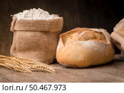 Rustic bread and wheat on an old vintage planked wood table. Стоковое фото, агентство Ingram Publishing / Фотобанк Лори