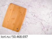 Top view of wooden cutting board on a gray marble background with space for text. Стоковое фото, агентство Ingram Publishing / Фотобанк Лори