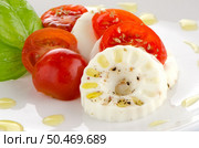 Fresh salad with goat cheese, tomato and basil pesto on a white plate. Стоковое фото, агентство Ingram Publishing / Фотобанк Лори