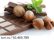 Chocolate Bar with hazelnuts and fresh mint on white background. Стоковое фото, агентство Ingram Publishing / Фотобанк Лори