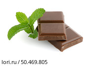 Closeup detail of chocolate parts and mint leaves on white background. Стоковое фото, агентство Ingram Publishing / Фотобанк Лори