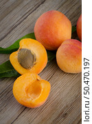 Apricots with leaves on the wooden table. Стоковое фото, агентство Ingram Publishing / Фотобанк Лори