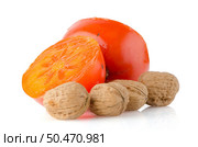 Ripe persimmons and nuts on white background. Стоковое фото, агентство Ingram Publishing / Фотобанк Лори