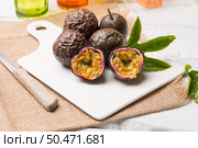 Passion fruits on white ceramic tray on wooden table background. Стоковое фото, агентство Ingram Publishing / Фотобанк Лори