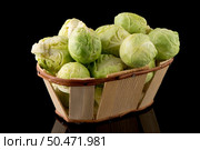 Fresh brussels sprouts and wooden baslet isolated on black background. Стоковое фото, агентство Ingram Publishing / Фотобанк Лори
