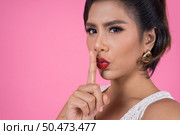 Beauty asian woman red lips and finger showing hush silence sign. Стоковое фото, агентство Ingram Publishing / Фотобанк Лори