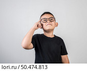 Funny Genius boy Thinking in studio shot. Стоковое фото, агентство Ingram Publishing / Фотобанк Лори