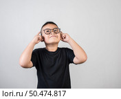 Funny Genius boy Thinking in studio shot. Стоковое фото, агентство Ingram Publishing / Фотобанк Лори