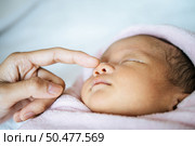 The mother’s hand touches the nose of the newborn baby. Стоковое фото, агентство Ingram Publishing / Фотобанк Лори