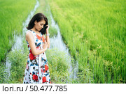 The woman stood strained and her hand touched the face in the meadow. Стоковое фото, агентство Ingram Publishing / Фотобанк Лори