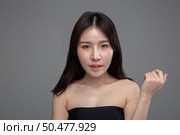 The woman wore a black strapless and raised her left hand. Стоковое фото, агентство Ingram Publishing / Фотобанк Лори
