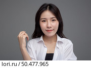 The woman wore a white shirt and raised her right hand. Стоковое фото, агентство Ingram Publishing / Фотобанк Лори