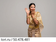 women is wearing Thai clothes and hand-made to cover her mouth. Стоковое фото, агентство Ingram Publishing / Фотобанк Лори