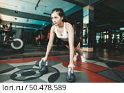 Women exercising by pushing the floor with the Kettlebell in the gym. Стоковое фото, агентство Ingram Publishing / Фотобанк Лори