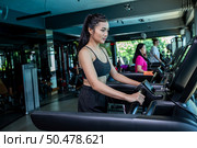 Beautiful fitness women prepare for running at the treadmill in the gym. Стоковое фото, агентство Ingram Publishing / Фотобанк Лори