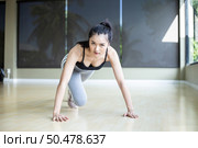 Young women warms up before exercising by pushing the floor and bending his knees in Gym. Стоковое фото, агентство Ingram Publishing / Фотобанк Лори