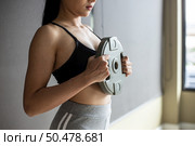 Women exercise with Dumbbell weight plates in the chest. Стоковое фото, агентство Ingram Publishing / Фотобанк Лори