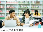 Women read books and men use laptops to search for books in libraries. Стоковое фото, агентство Ingram Publishing / Фотобанк Лори