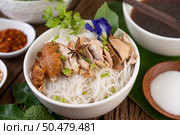 Chicken noodle in a bowl with side dishes, Thai food. Selective focus. Стоковое фото, агентство Ingram Publishing / Фотобанк Лори