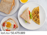 Omelette, fried egg and sandwiches are in a color palette on a white background for breakfast. Стоковое фото, агентство Ingram Publishing / Фотобанк Лори