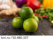 Lime piles on the floor with kaffir lime leaves. Chilli and ginger. Selective focus. Стоковое фото, агентство Ingram Publishing / Фотобанк Лори