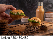 Burger with wooden cutting board, including cupcakes and coffee beans. Selective focus. Стоковое фото, агентство Ingram Publishing / Фотобанк Лори