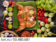 Grilled chicken on a plate with chili peppers, garlic sauce and sprinkled with pepper seeds. Стоковое фото, агентство Ingram Publishing / Фотобанк Лори
