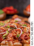 Pizza placed on a wooden plate complete with pepper seeds. Tomatoes and garlic. Selective focus. Стоковое фото, агентство Ingram Publishing / Фотобанк Лори