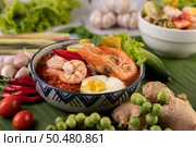 Tom Yum noodle with shrimp and boiled egg, accompanied by lime, cucumber, basil, eggplant and garlic. Стоковое фото, агентство Ingram Publishing / Фотобанк Лори