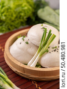 Steamed buns in a wooden dish on a wooden grill. Selective focus. Стоковое фото, агентство Ingram Publishing / Фотобанк Лори