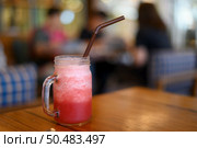 Red water blended in a glass, put on a wooden table. Стоковое фото, агентство Ingram Publishing / Фотобанк Лори