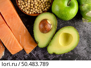 Legumes, fruit, and salmon placed on a black cement floor. Стоковое фото, агентство Ingram Publishing / Фотобанк Лори