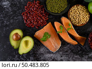 Legumes, fruit, and salmon placed on a black cement floor. Стоковое фото, агентство Ingram Publishing / Фотобанк Лори