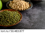 Mung bean and Soy bean on the plate on a black cement floor background. Стоковое фото, агентство Ingram Publishing / Фотобанк Лори